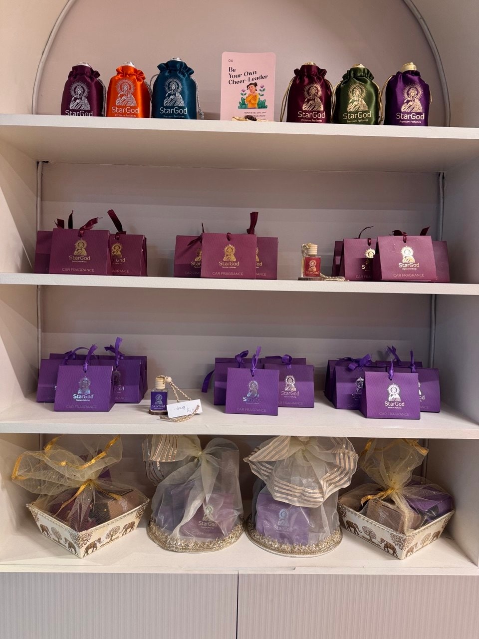 The gifting alcove — satin pouches on top, gift boxes in the middle, mesh-wrapped hampers below.